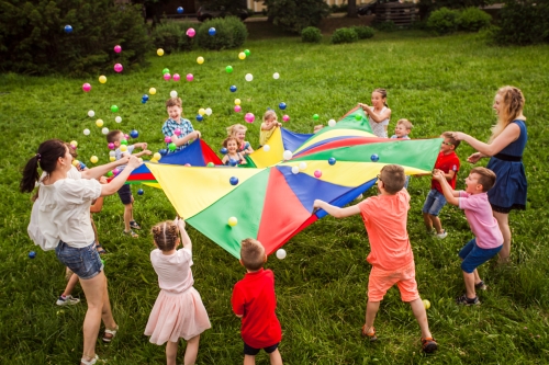 kids outside playing with a parachute
